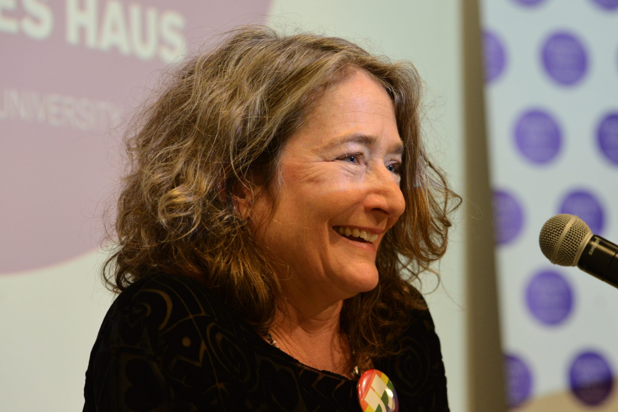Barbara Epler on stage, smiling in a black shirt